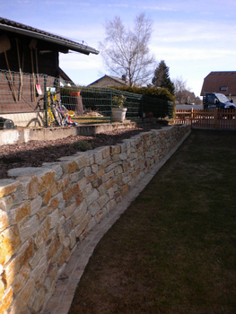 Natursteinmauer mit Rasenmähkante